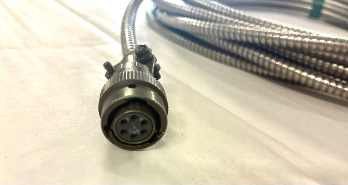 Close-up of 6-socket female circular connector insert lettered A-F on armored cable
