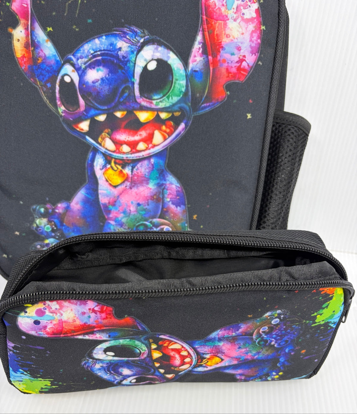 Close-up of Stitch watercolor print on the backpack front with the pencil case open in front