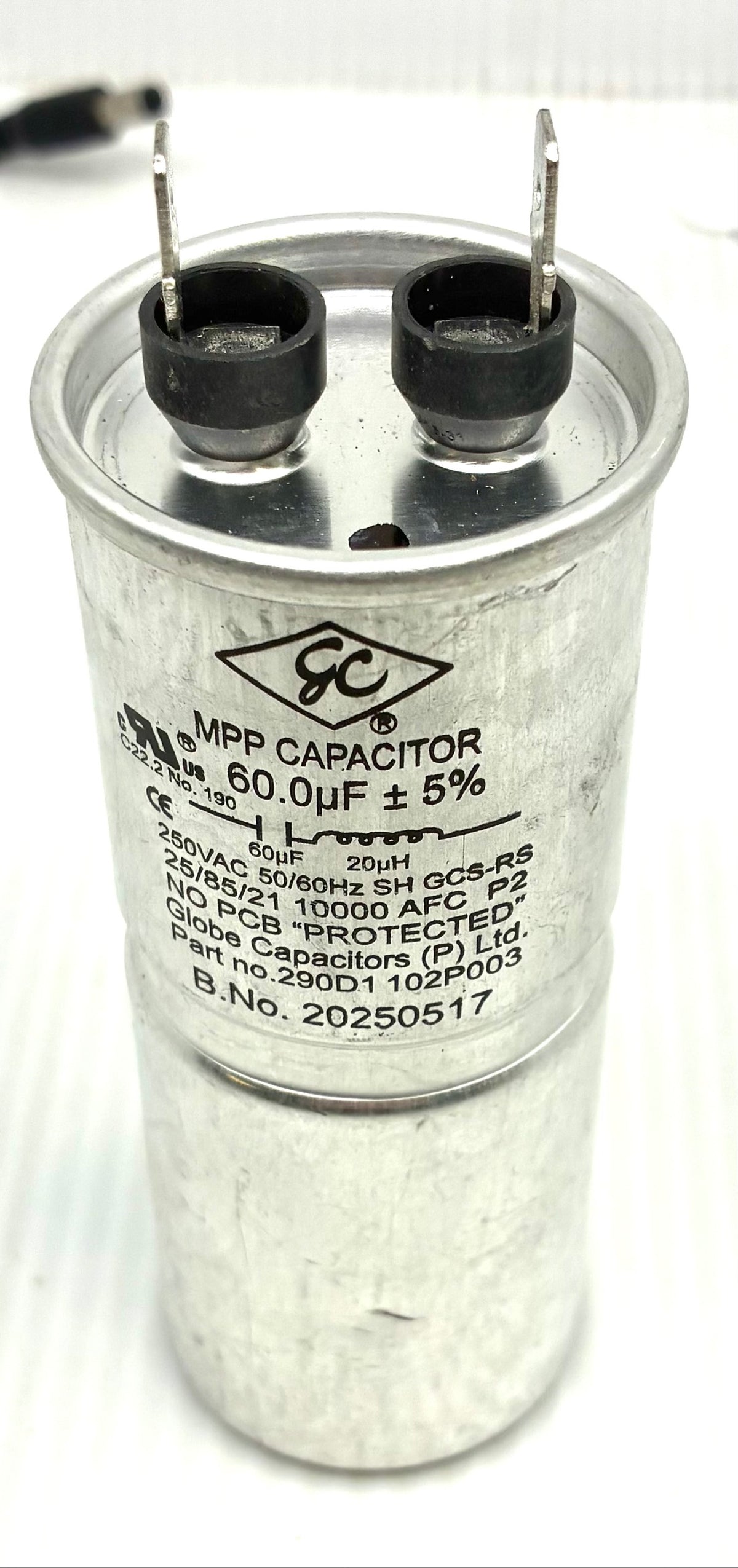 Top view of GE washer capacitor terminals and Globe Capacitors label close-up