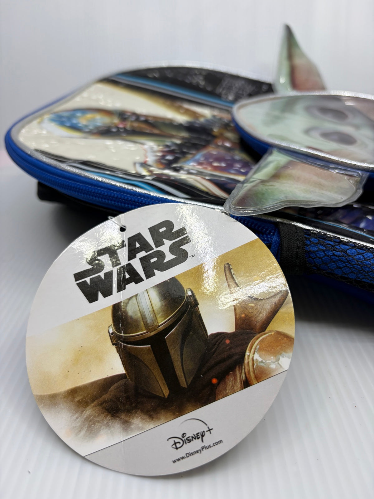 Round Star Wars hangtag with Mandalorian helmet art and Disney Plus logo attached to the backpack