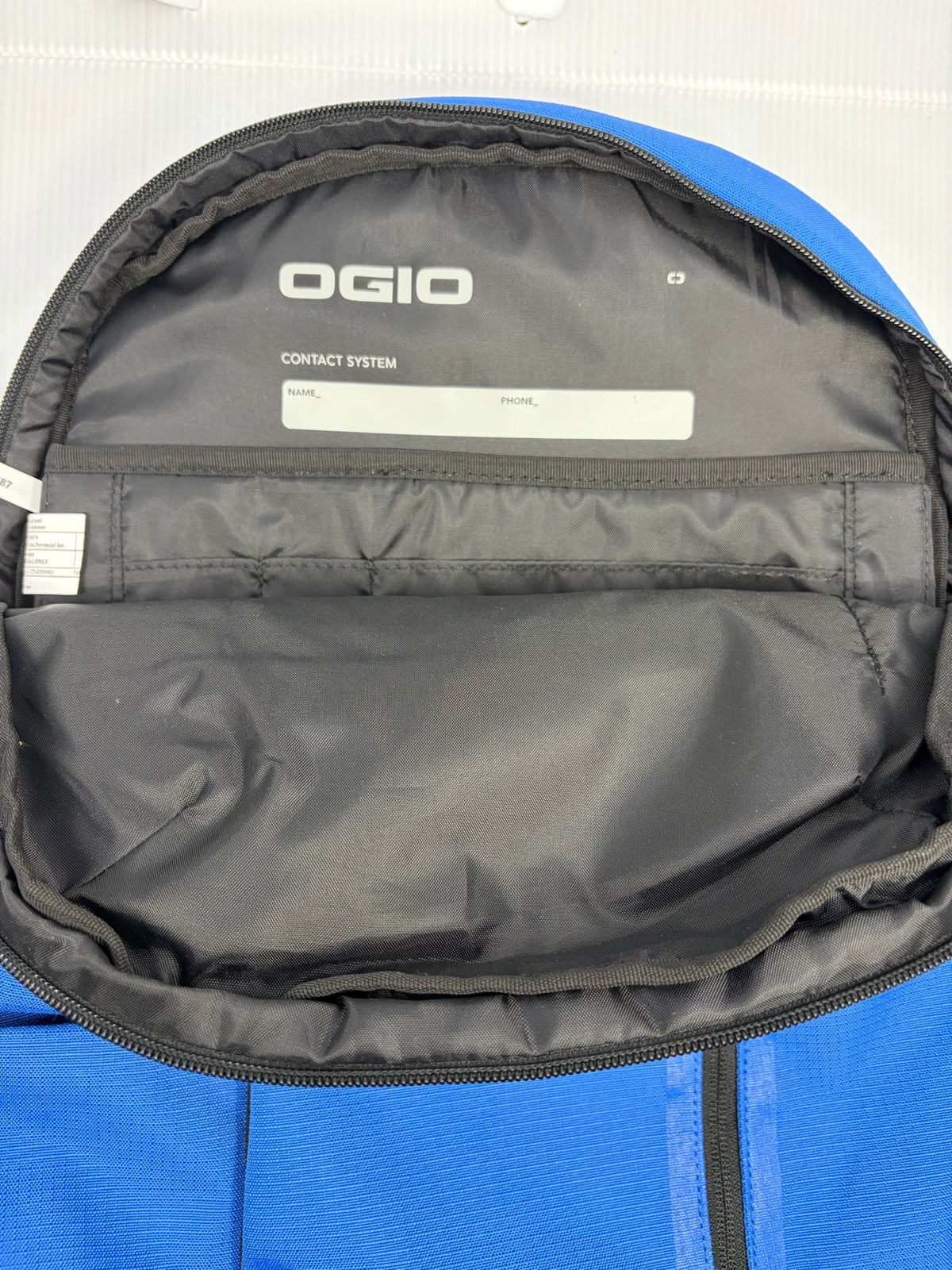 Interior organizer compartment of the OGIO Shadow backpack with slip pockets and Contact System name and phone label