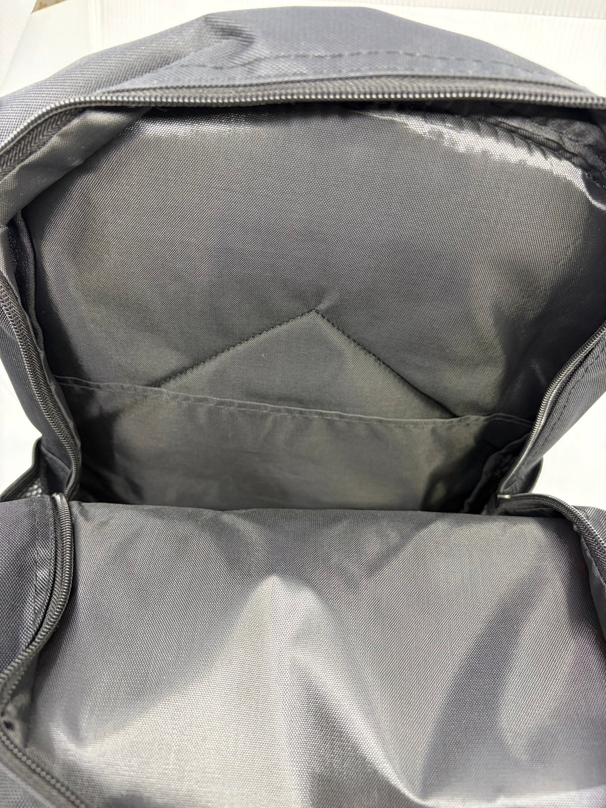 Backpack main compartment interior open showing black lining and interior slip pocket