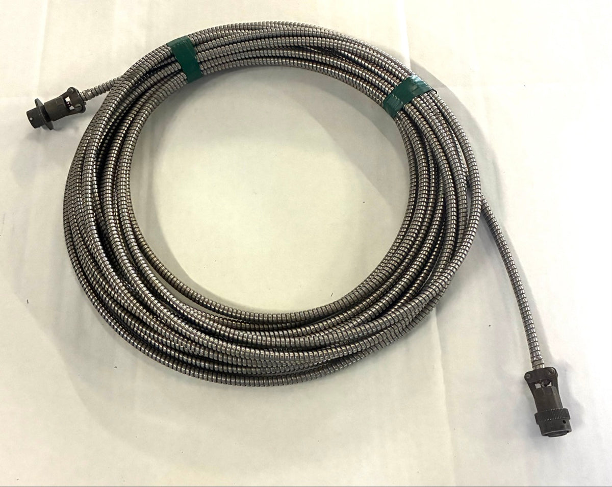 Armored extension cable coil viewed from above with circular connectors at each end