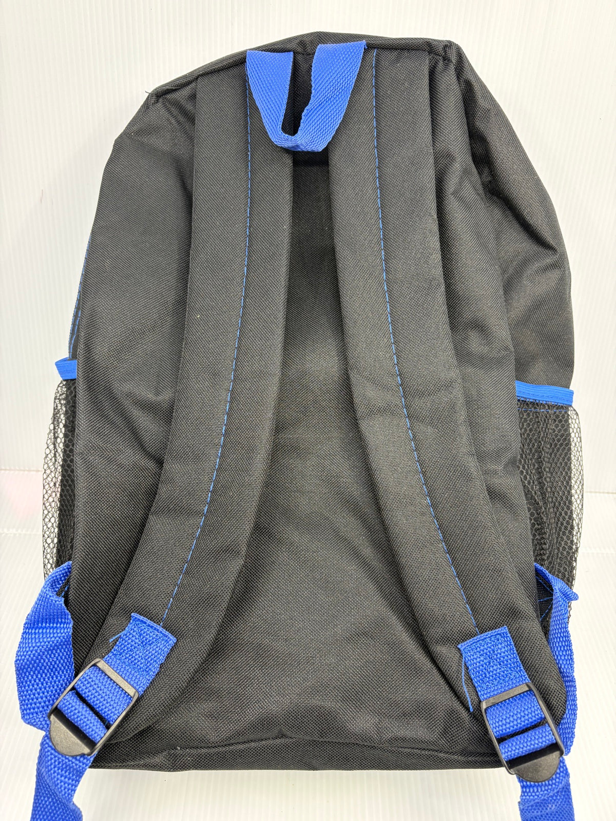 Back of the Mandalorian backpack showing black padded shoulder straps, blue adjustment webbing and buckles, blue top grab loop and mesh side pockets