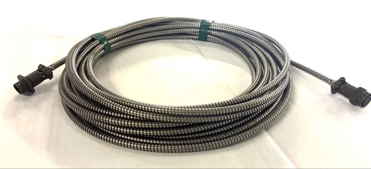 Low angle view of coiled interlocked metal armored cable with 6-pin circular connectors