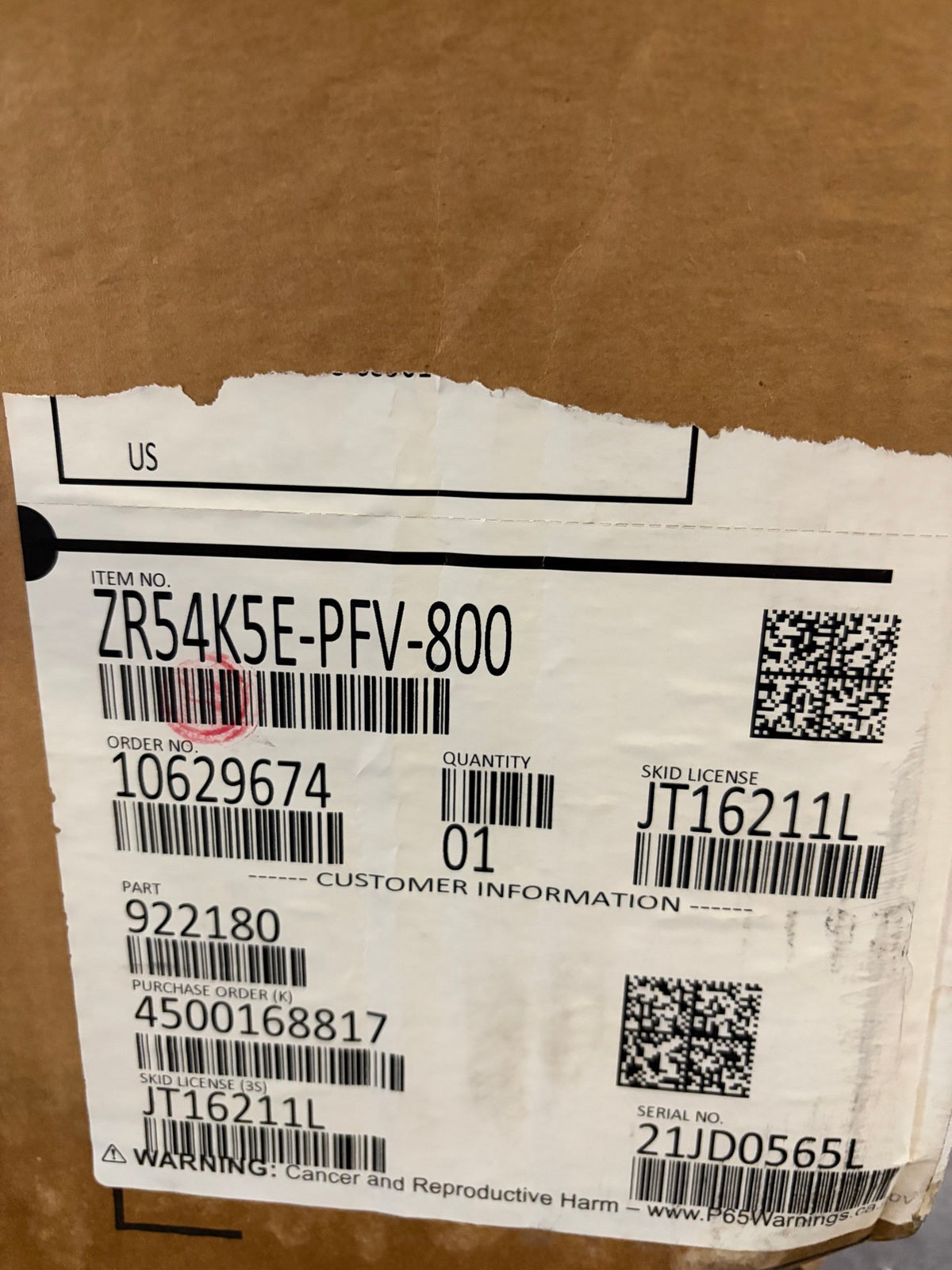 Original carton label for Copeland ZR54K5E-PFV-800, quantity 01, serial 21JD0565L matching the compressor nameplate; carton is damaged