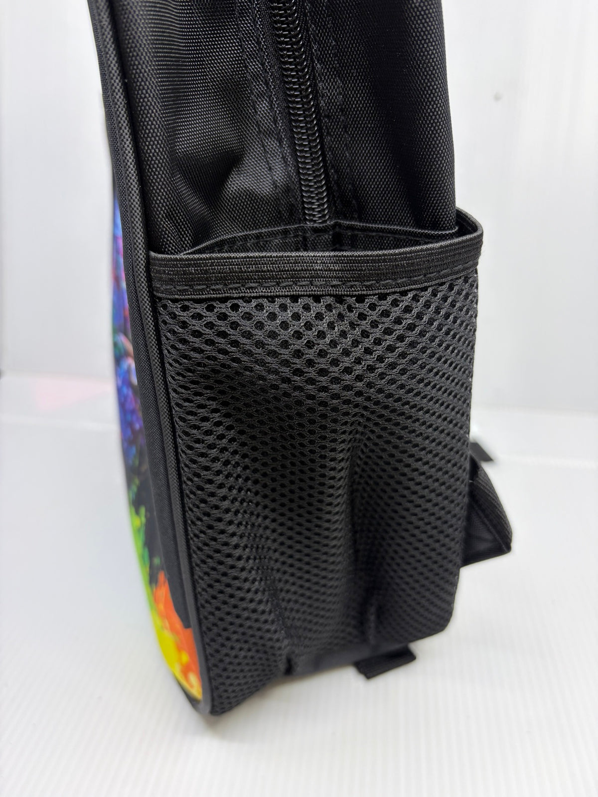 Side view of the backpack showing mesh water bottle pocket and zipper