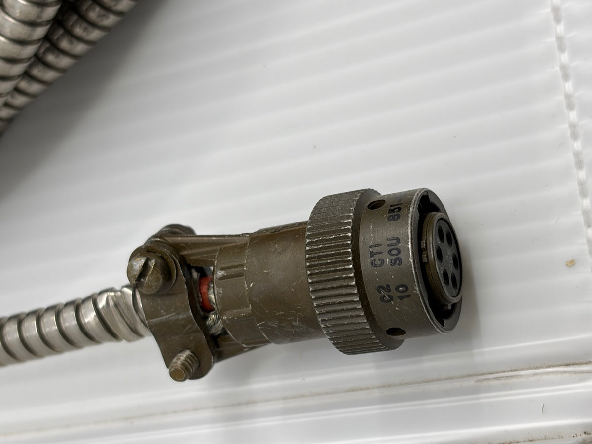 Close-up of Souriau female plug showing SOU maker mark, cable clamp, shield braid and olive drab finish