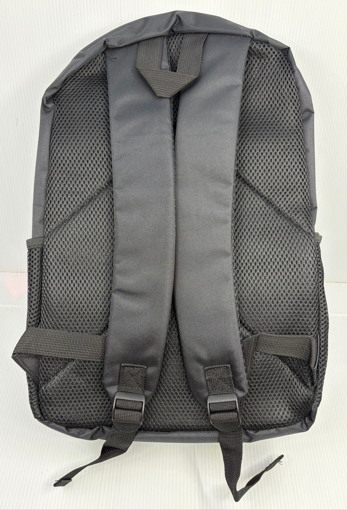 Back of the backpack showing padded mesh back panel, padded adjustable shoulder straps and top grab loop
