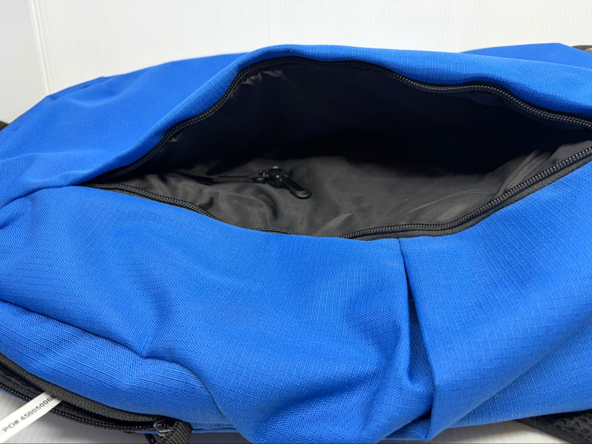 Main compartment of the OGIO Shadow backpack open, showing interior zip pocket and PO tag