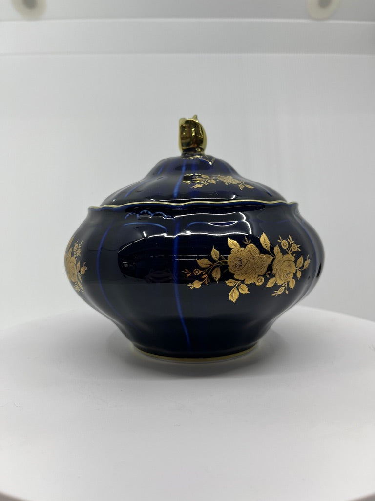 Blue ceramic pot with gold floral patterns on a white background