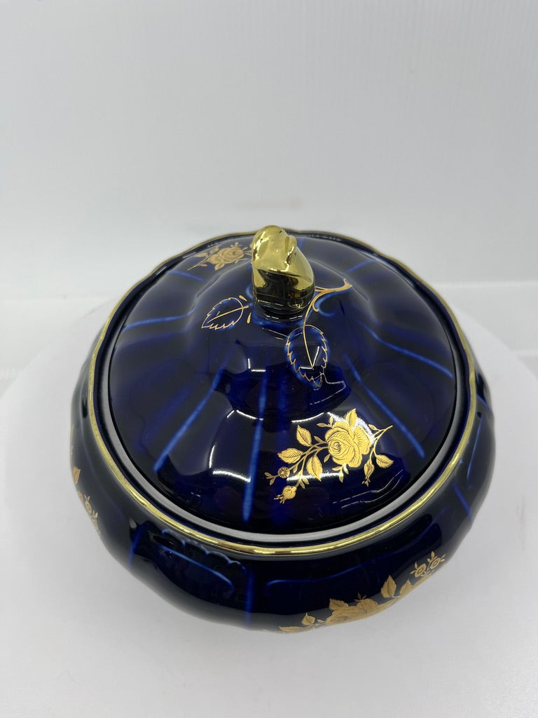 Blue decorative ceramic bowl and lid with gold accents on a white background