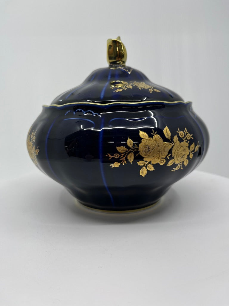 Decorative blue bowl with hand paingted gold floral patterns on a white background