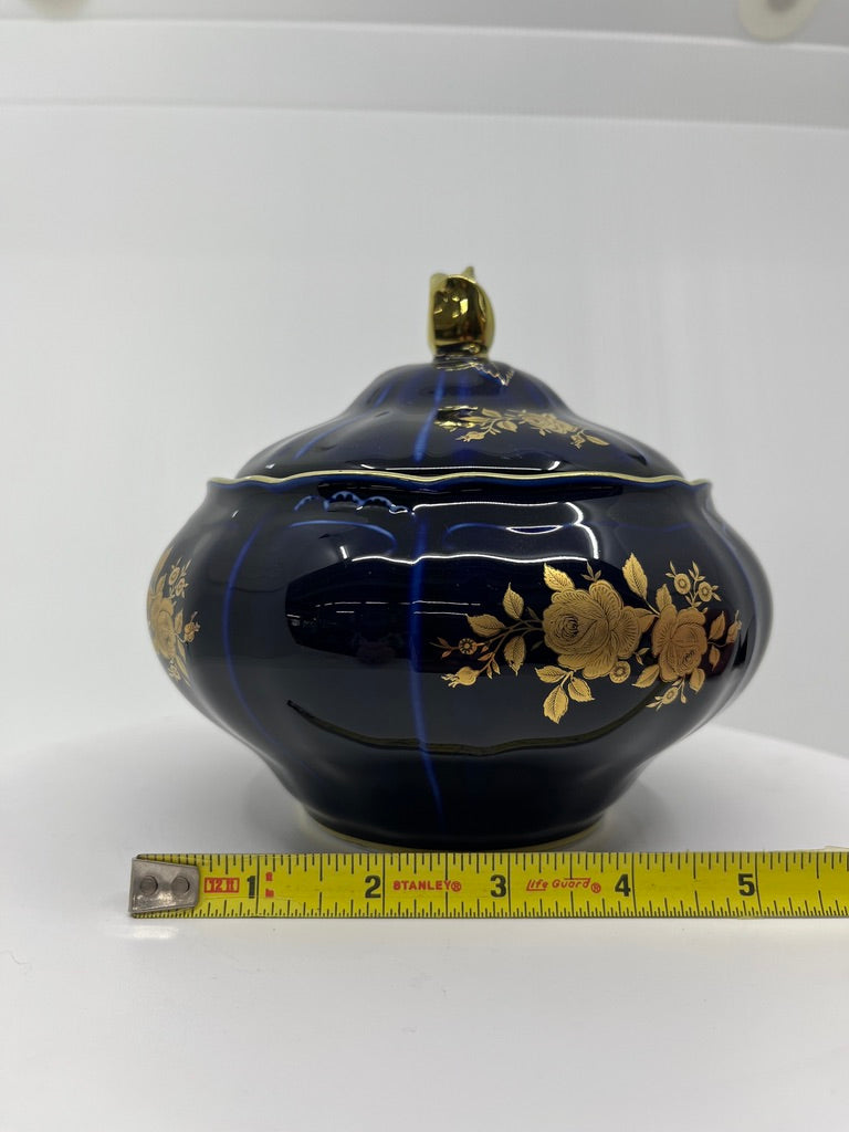 Decorative blue vase with hand painted gold floral patterns, measured against a white background
