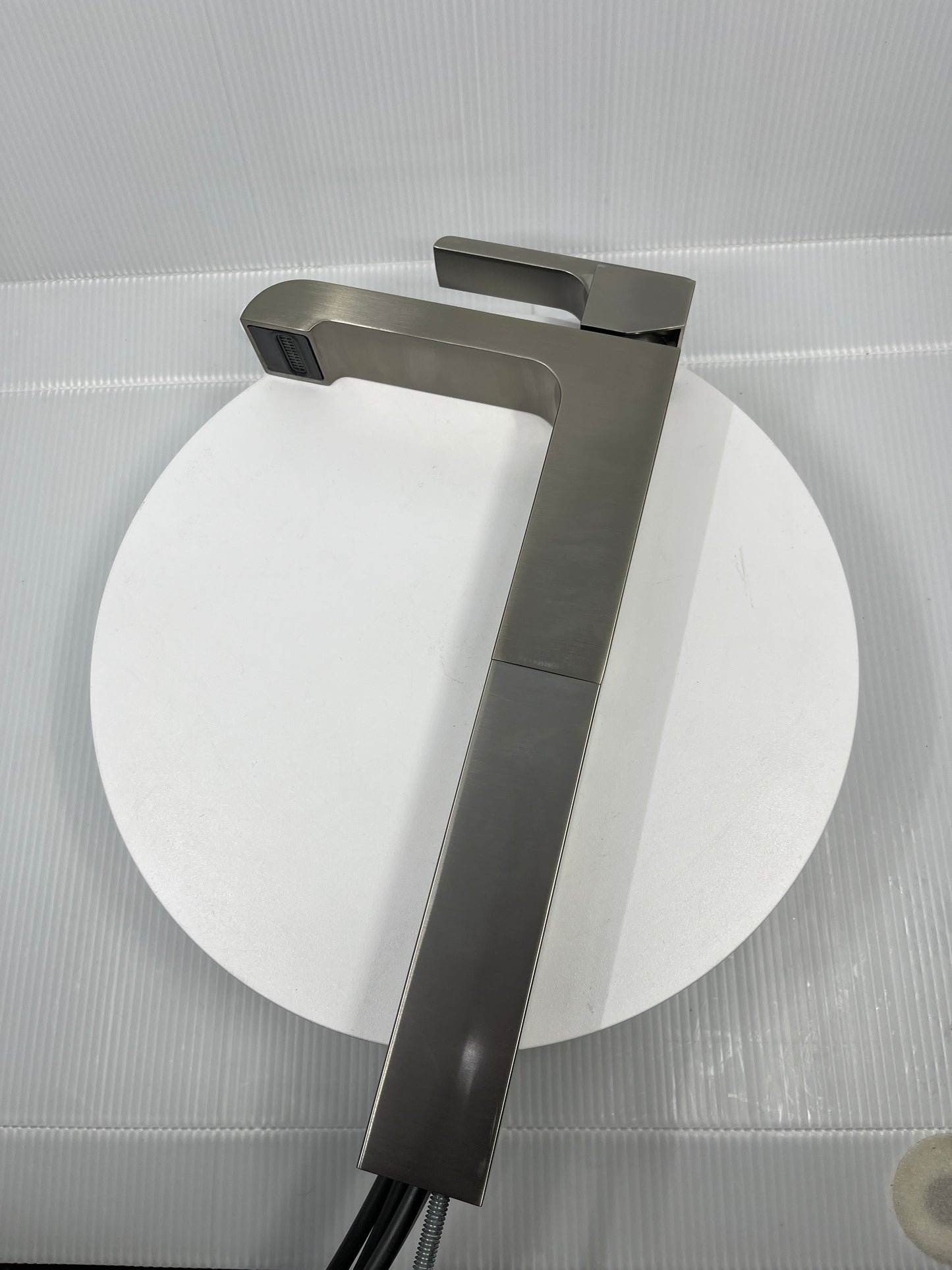 Delta Faucet Ara Single Handle Vessel Bathroom Faucet In Stainless 767LF-SS on circular display table background.