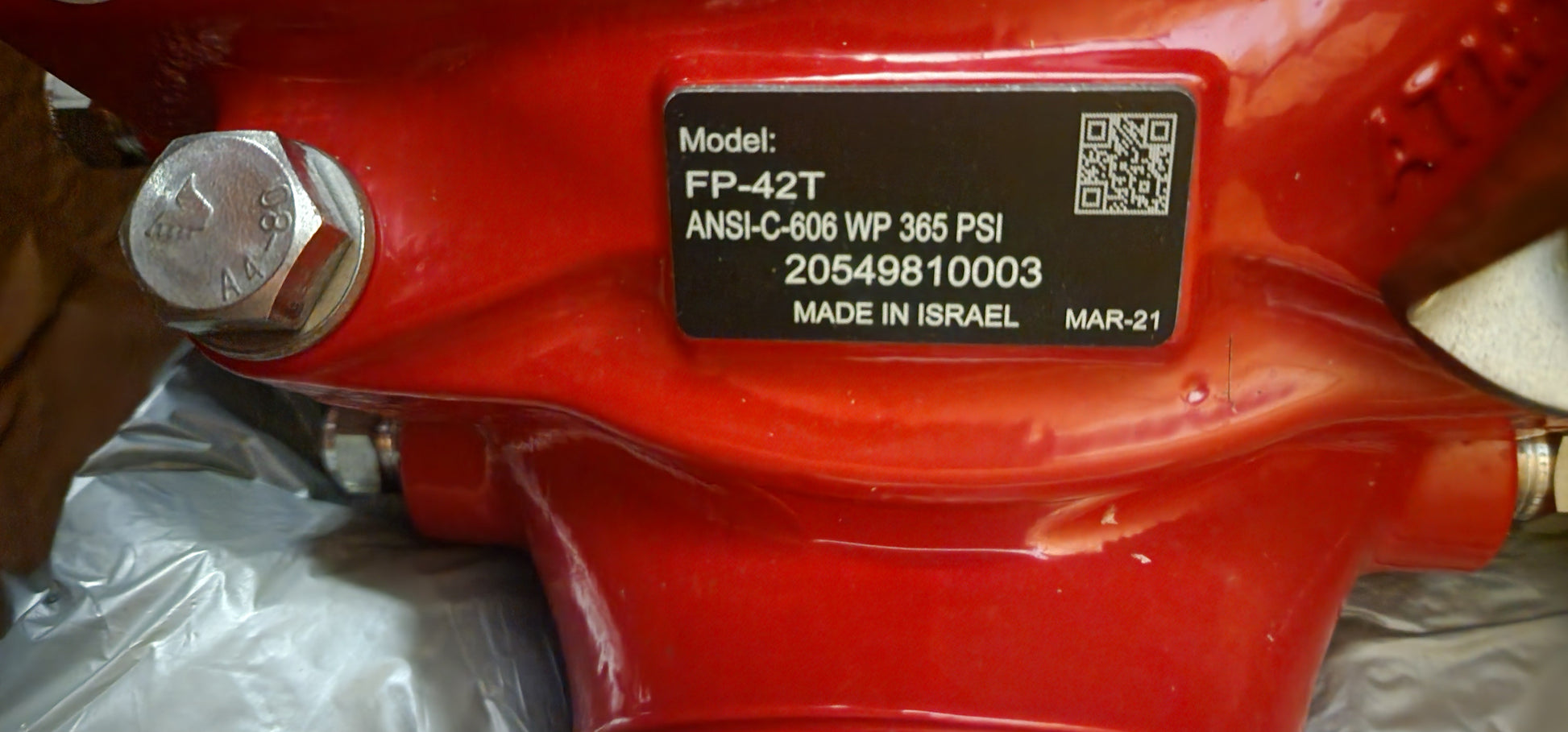 Red mechanical valve with a label displaying technical details