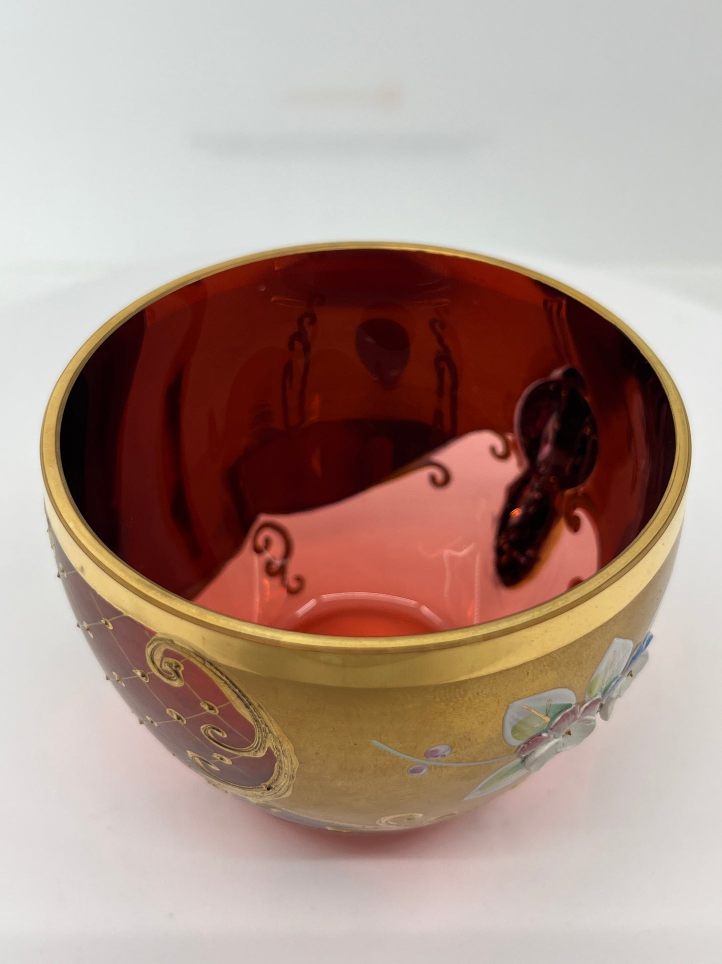 Decorative glass teacup with intricate designs on a white background.