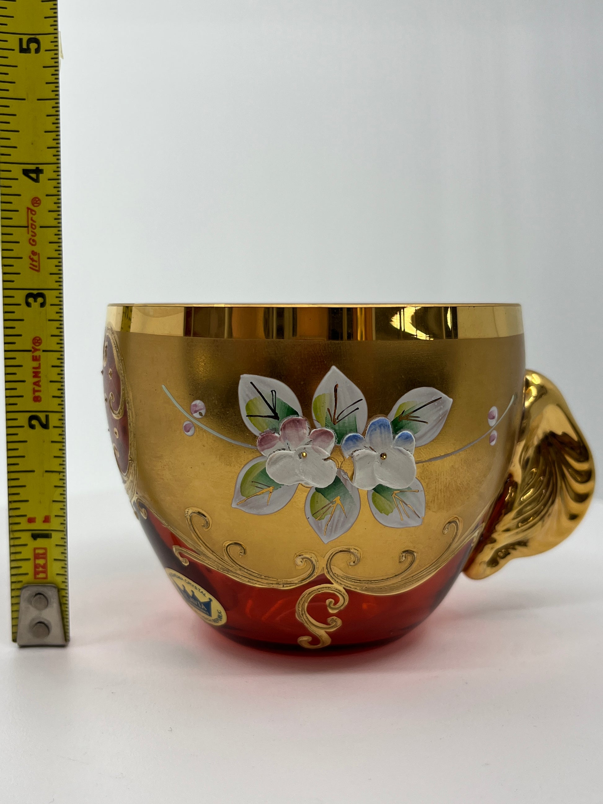 Decorative punchbowl teacup with floral design and gold accents, measured against a ruler.